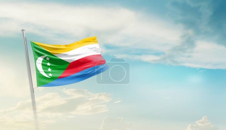 Comoras ondeando bandera contra el cielo azul con nubes