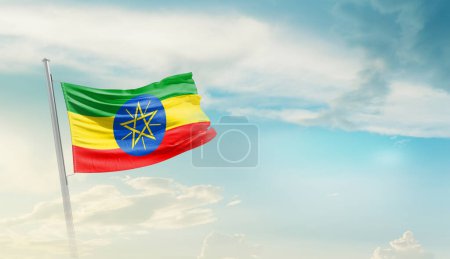Téléchargez les photos : Éthiopie agitant le drapeau contre le ciel bleu avec des nuages - en image libre de droit