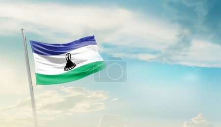 Foto de Lesotho ondeando bandera contra el cielo azul con nubes - Imagen libre de derechos