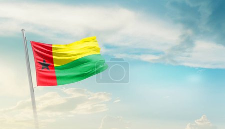 Guinea-Bissau schwenkt Flagge gegen blauen Himmel mit Wolken