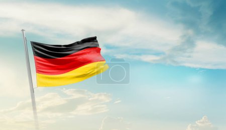 Deutschland schwenkt Flagge gegen blauen Himmel mit Wolken