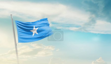 Somalie agitant le drapeau contre le ciel bleu avec des nuages