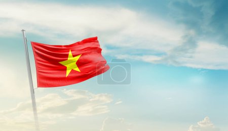 Vietnam waving flag against blue sky with clouds