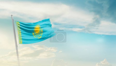 Foto de Kazajstán ondeando bandera contra el cielo azul con nubes - Imagen libre de derechos