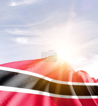 Trinidad und Tobago schwenken Flagge gegen blauen Himmel mit Wolken