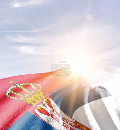 Serbia waving flag against blue sky with clouds