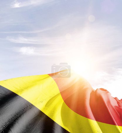 Foto de Bélgica ondeando bandera contra el cielo azul con nubes - Imagen libre de derechos