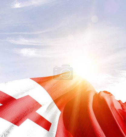Foto de Tonga ondeando bandera contra el cielo azul con nubes - Imagen libre de derechos