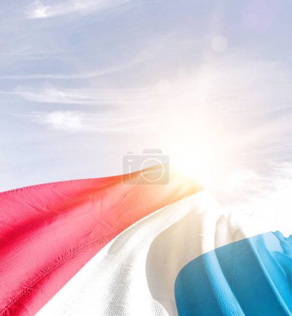 Foto de Luxemburgo ondeando bandera contra el cielo azul con nubes - Imagen libre de derechos