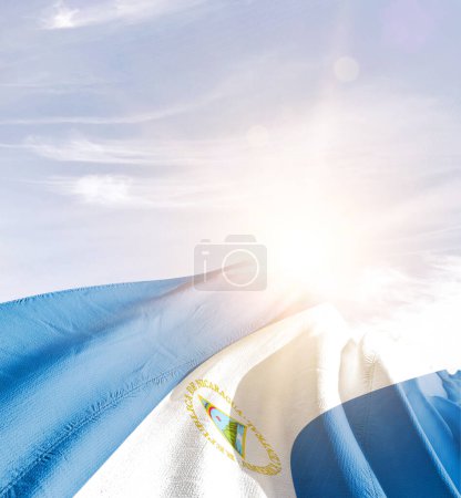 Téléchargez les photos : Nicaragua agitant le drapeau contre le ciel bleu avec des nuages - en image libre de droit