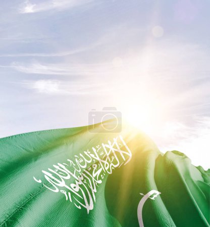 Foto de Arabia Saudita ondeando bandera contra el cielo azul con nubes - Imagen libre de derechos