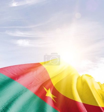 Téléchargez les photos : Cameroun agitant le drapeau contre le ciel bleu avec des nuages - en image libre de droit