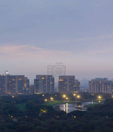 Gurgaon,Haryana,India colorful sunset on a foggy winter evening.Aerial view of Gurugram urban cityscape with modern architecture,commercial,luxury residential apartment buildings.Delhi NCR beautiful skyline with city lights.