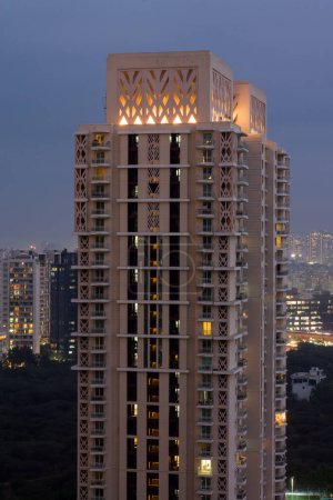 Foto de Gurgaon, Haryana, India colorido atardecer en una noche de invierno niebla. Vista aérea del paisaje urbano Gurugram con arquitectura moderna, comercial, edificios de apartamentos residenciales de lujo. Delhi NCR. - Imagen libre de derechos