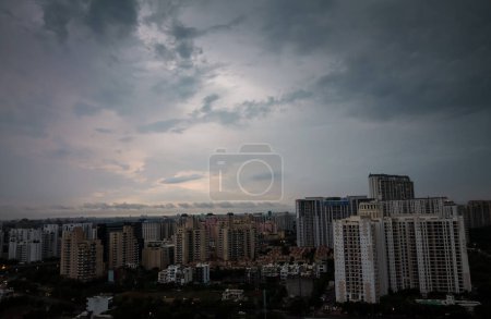 Gurgaon, Haryana, Indien farbenfroher Sonnenuntergang im Monsun. Luftaufnahme der Stadtsilhouette von Gurugram mit moderner Architektur, Gewerbe, Luxus-Wohngebäuden. Delhi NCR schöne Stadtlandschaft mit Wolken, Stadtbeleuchtung.