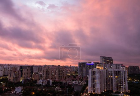 Gurgaon,Haryana,India colorful sunset in monsoon .Aerial view of Gurugram urban skyline with modern architecture,commercial,luxury residential apartment buildings.Delhi NCR beautiful urban cityscape with cllouds,city lights.