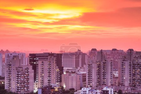 Gurgaon, Haryana, Indien Skyline mit bunten Sonnenuntergang während der Monsun.Luftaufnahme von Gurugram Stadtbild mit moderner Architektur, kommerziellen, luxuriösen Wohngebäuden.Stadtbeleuchtung am Abend in Premium-Geschäftsviertel, Delhi NCR.