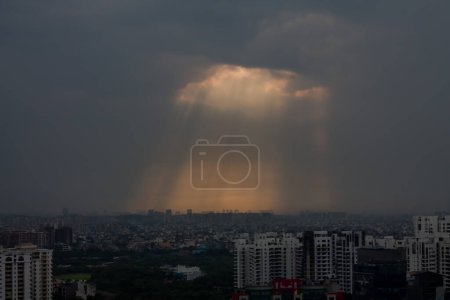 Téléchargez les photos : Gurgaon, Haryana, Inde horizon urbain au coucher du soleil.Gurugram paysage urbain avec architecture moderne, bâtiments commerciaux et résidentiels de luxe.Rayons de soleil rayonnant vers le bas, couverture nuageuse pendant la mousson.. - en image libre de droit