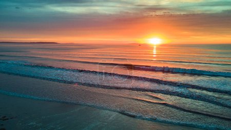 Téléchargez les photos : Image du lever de soleil magique aérien sur la plage avec des vagues océaniques dans le Maine - en image libre de droit