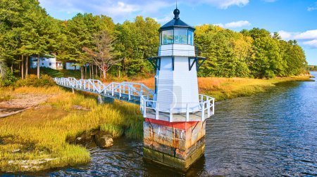 Photo for Image of Adorable tiny lighthouse on Maine coast with walkway and fall foliage - Royalty Free Image