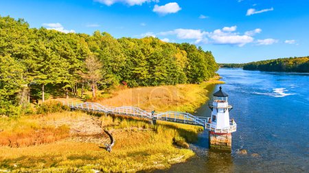 Photo for Image of Aerial of small lighthouse Doubling Point on Maine Coast with fall foliage and warm light - Royalty Free Image