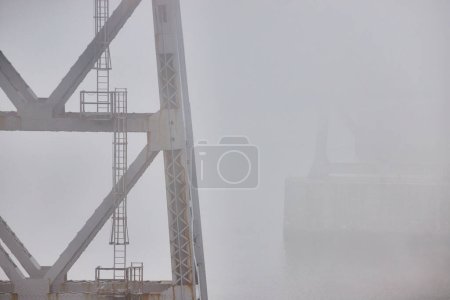 Foto de Imagen de Pilares de soporte de puente de acero viejo con escaleras que se desvanecen en la mañana brumosa clima extremo - Imagen libre de derechos