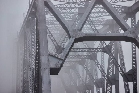 Photo for Image of Foggy morning over large steel bridge detail of top fading away - Royalty Free Image