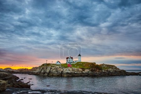 Imagen de la mañana nublada del amanecer sobre la serena isla de Maine con faro
