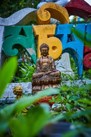 Photo for Image of Garden plants surround buddha statue and colorful lettering - Royalty Free Image