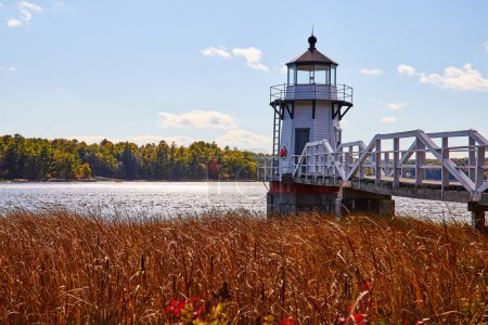 Photo for Image of Red fields surround white lighthouse in Maine along river - Royalty Free Image