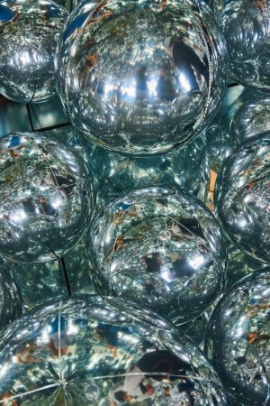 Téléchargez les photos : Image de détail de dizaines de ballons réfléchissants en hélium miroir montrant plus de sphères et de touristes - en image libre de droit