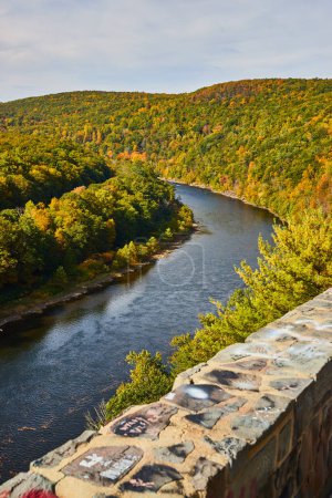 Foto de Imagen del enorme río Delaware en el bosque de principios de otoño junto a la pared de piedra con graffiti de arte con tiza - Imagen libre de derechos