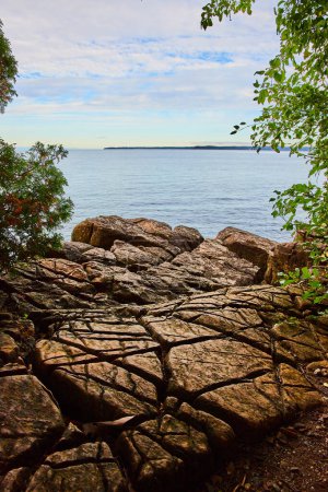 Photo for Image of Rocky surface with large cuts in all directions overlooking lake on cloudy day - Royalty Free Image