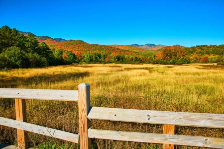 Téléchargez les photos : Image de Clôture à côté de champs jaunes et d'énormes montagnes d'automne colorées à New York - en image libre de droit