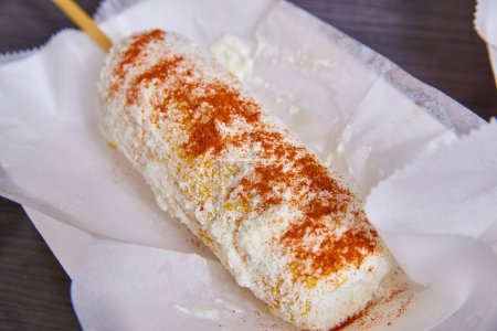Image of Elotes elote corn street food Mexican food dish cotija cheese spicy chili powder on white dish