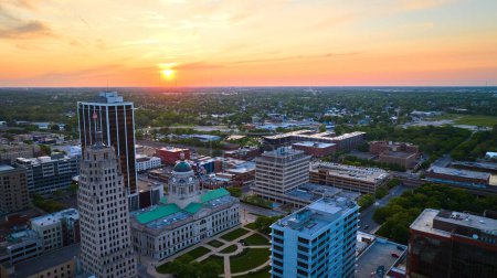 Téléchargez les photos : Image du panorama aérien horizontal lever de soleil doré sur le centre-ville de Fort Wayne en mettant l'accent sur le palais de justice - en image libre de droit