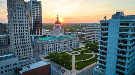 Téléchargez les photos : Image du soleil doré derrière le palais de justice en été antenne du centre-ville de Fort Wayne - en image libre de droit