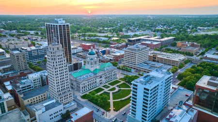 Téléchargez les photos : Image du lever du soleil au-dessus du cœur du centre-ville de Fort Wayne avec les principaux immeubles de bureaux aériens - en image libre de droit