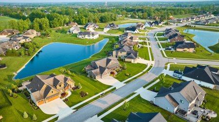 Image of Aerial large ponds in rich expensive neighborhood with mini mansions, high-end, million-dollar homes