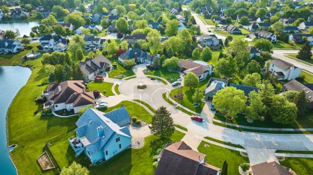 Image of Cul-de-sac with large to middleclass homes in neighborhood with pond in summertime aerial