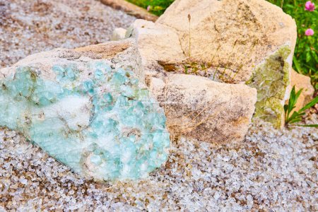 Foto de Imagen de Baby sky blue glass fusionada en roca de hormigón con pequeños fragmentos de vidrio transparente en el suelo - Imagen libre de derechos