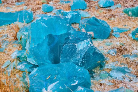 Foto de Imagen de Magníficos fragmentos de azul turquesa descansando en una orilla de fragmentos de vidrio transparente roto - Imagen libre de derechos