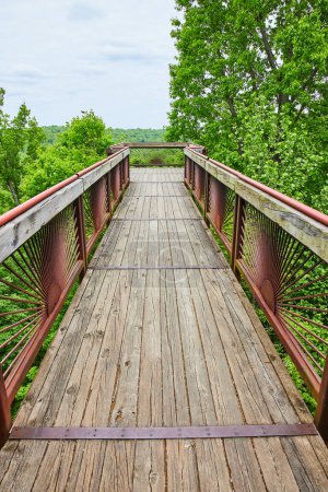 Photo for Image of Bernheim Forest boardwalk bridge leading to tree top overlook with rusty red railing and wood planks - Royalty Free Image