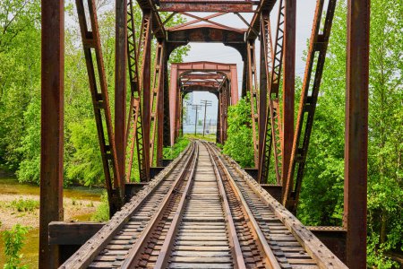 Téléchargez les photos : Image du vieux pont ferroviaire en fer avec des voies ferrées virant loin dans la ville lointaine - en image libre de droit