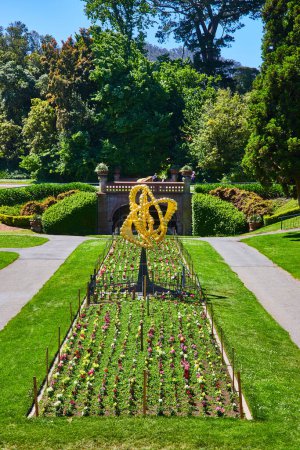 Foto de Imagen de Arte abstracto amarillo con pequeñas bolas doradas en el centro del macizo de flores en un gran parque - Imagen libre de derechos