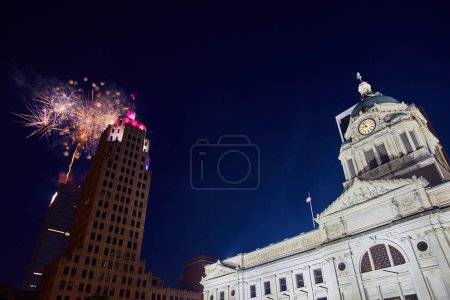 Téléchargez les photos : Image des gratte-ciel et du palais de justice de Fort Wayne le 4 juillet avec des feux d'artifice derrière la tour Lincoln - en image libre de droit