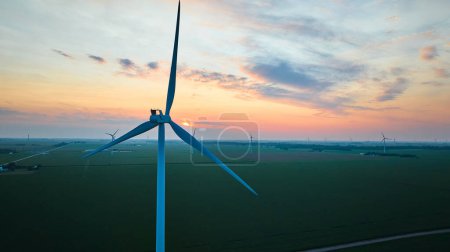 Photo for Image of Gorgeous pink and gold sunset aerial on wind farm close up of turbine in field - Royalty Free Image