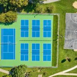 Image of Straight down aerial tennis courts and basketball court on summer day