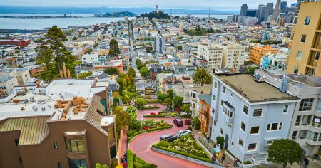 Téléchargez les photos : Image de la rue aérienne Lombard courbant la route de brique rouge avec des voitures et vue du centre-ville de San Francisco - en image libre de droit