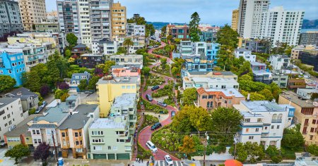 Téléchargez les photos : Image de Low aerial Lombard Street avec maisons et voitures et vue sur la ville - en image libre de droit